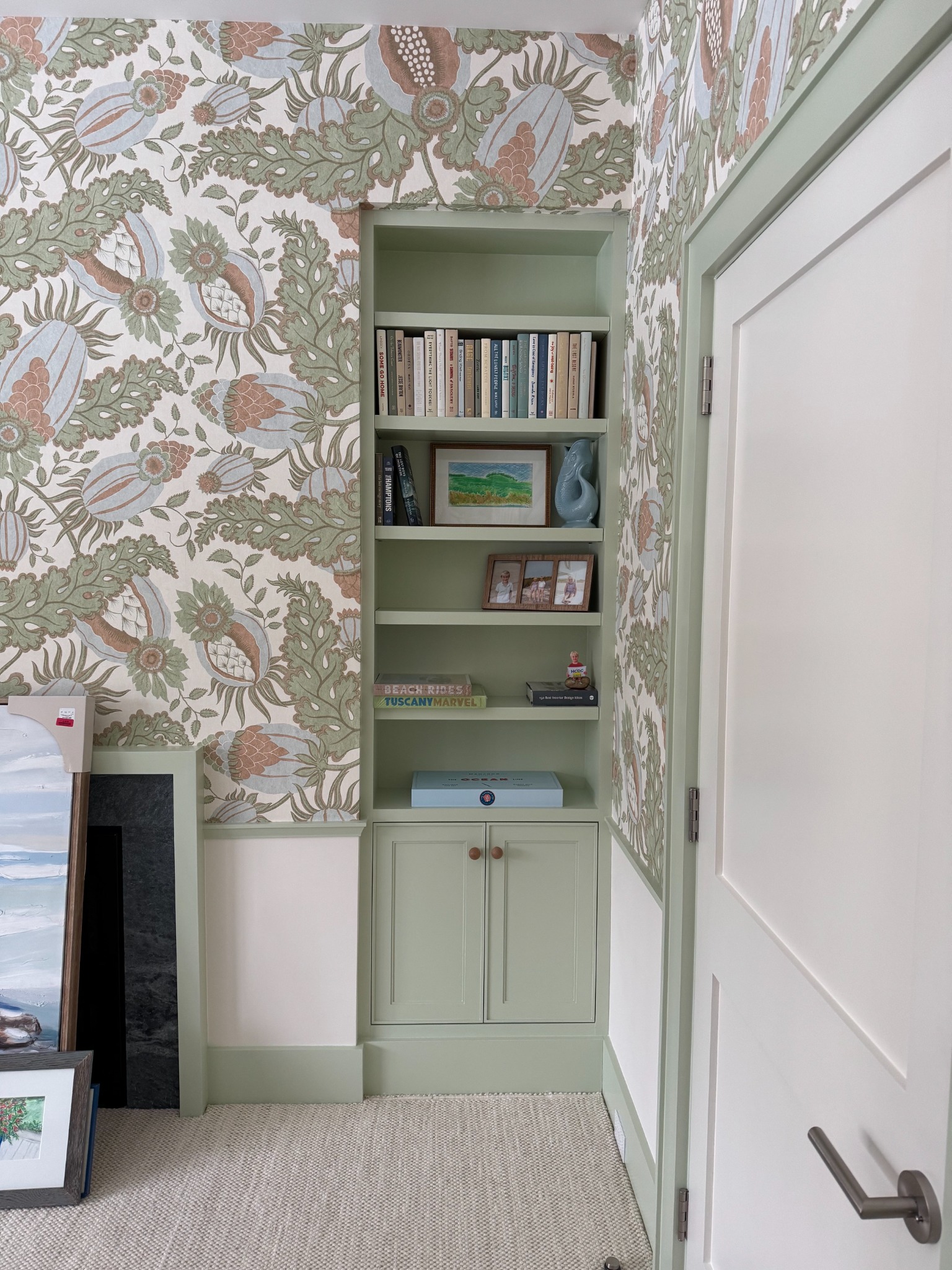 Painted primary bedroom bookcase integrated into patterned wall covering