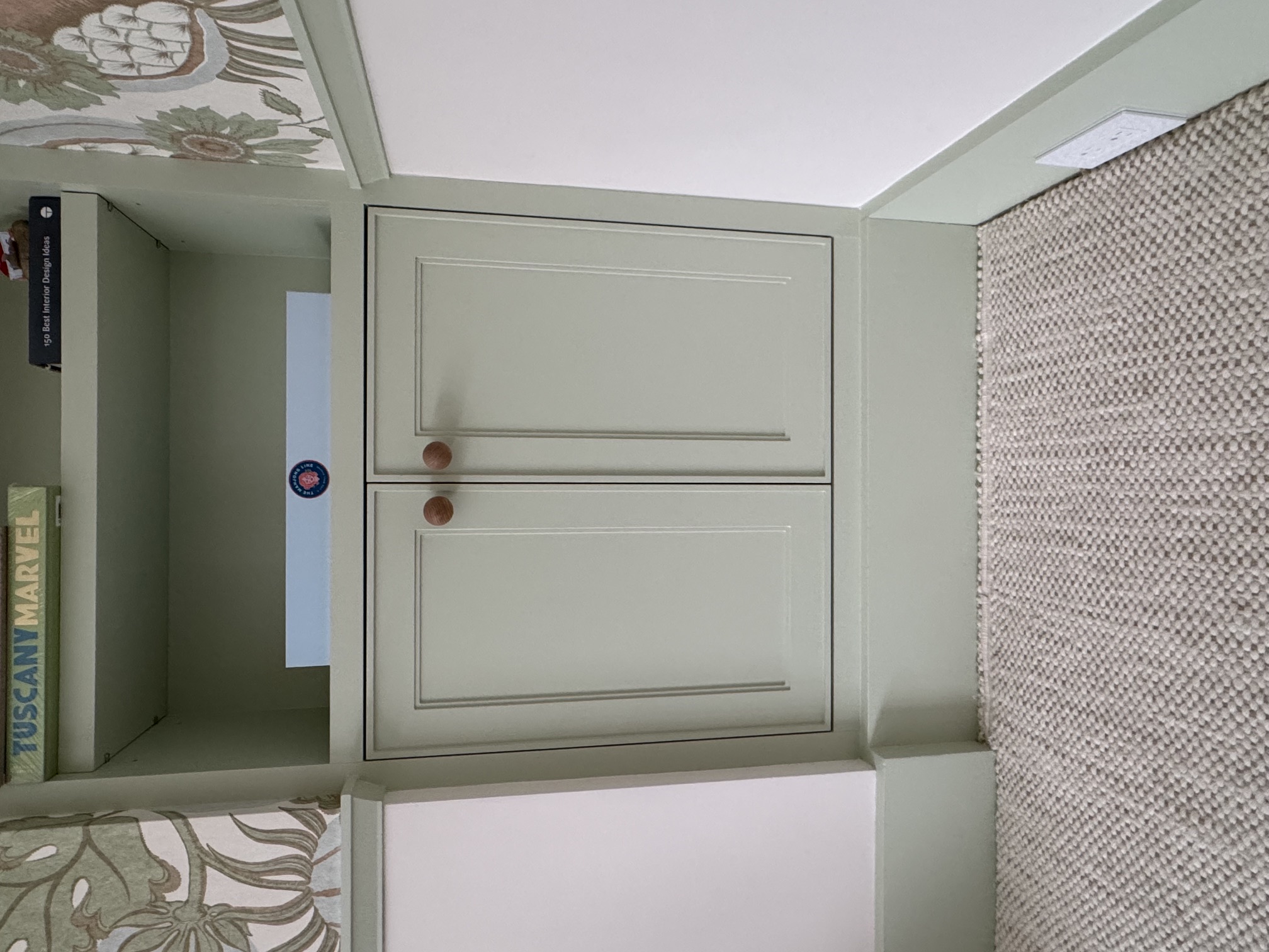 Close detail of the finished green cabinet doors with installed wood knobs