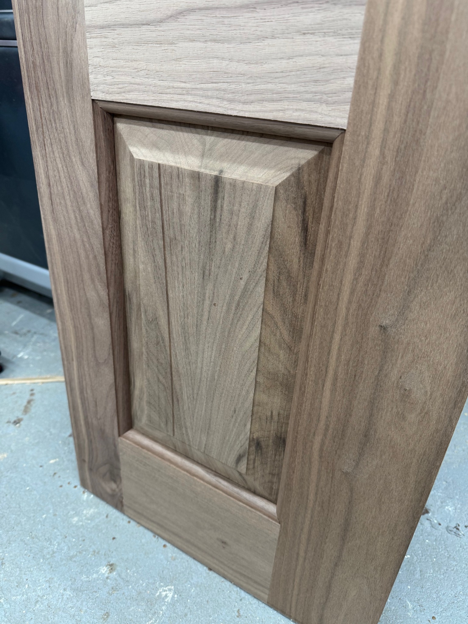 Close view of a custom walnut raised panel and moulded frame