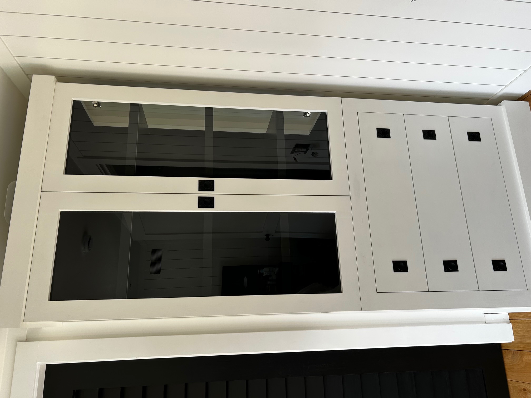 Close view of a glass-front cabinet with black interior shelves and fitted drawers