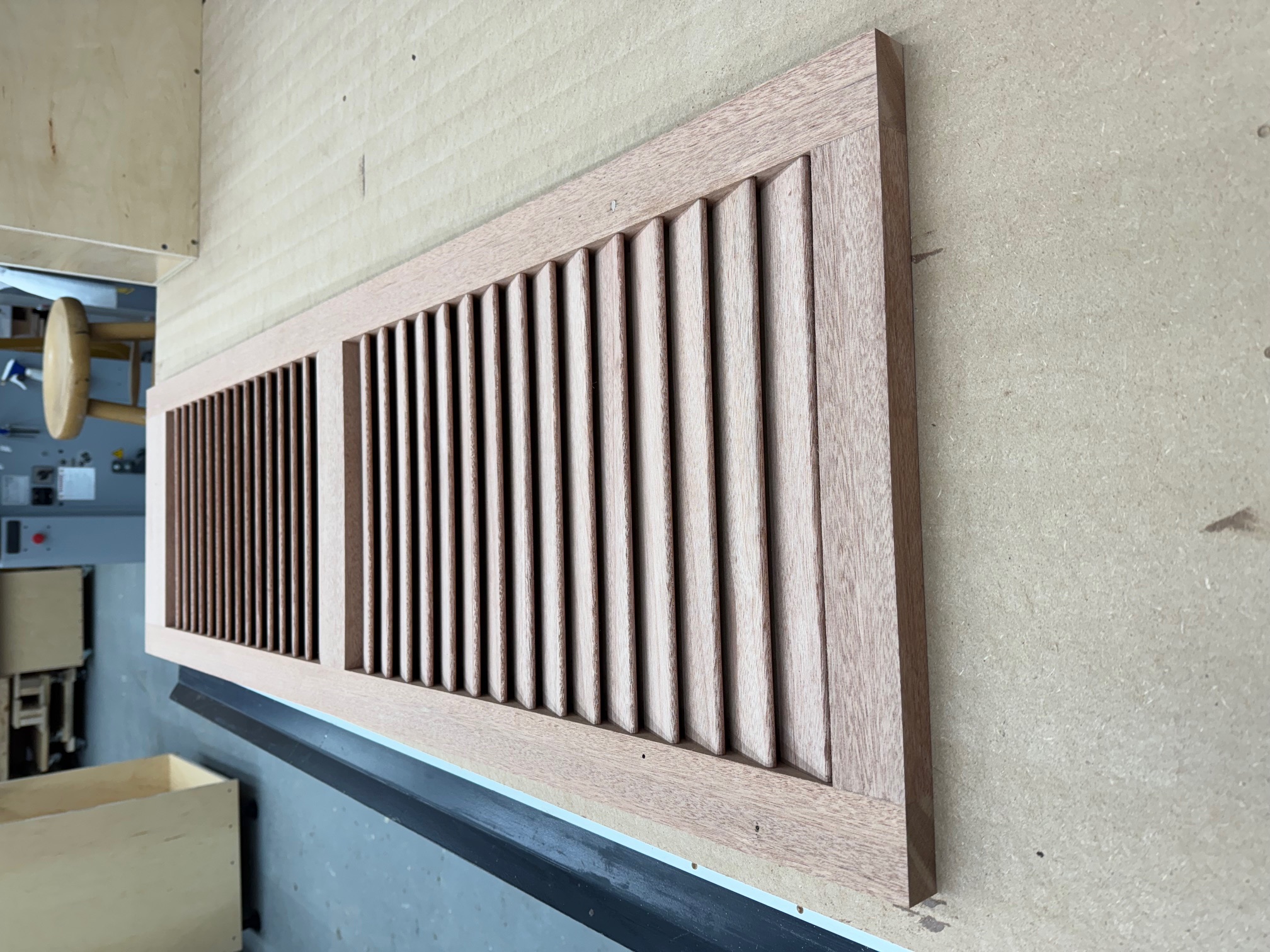 Custom mahogany louvered shutter during fabrication in the Maidstone shop