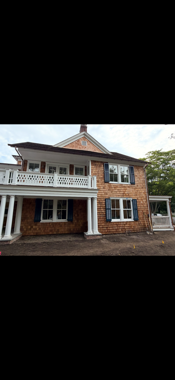 Main Street residence in East Hampton Village with custom dark louvered shutters installed across the exterior