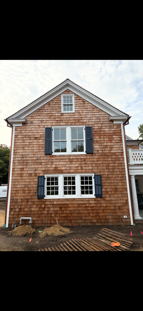 Side elevation of the cedar-shingled Main Street residence with paired custom shutters