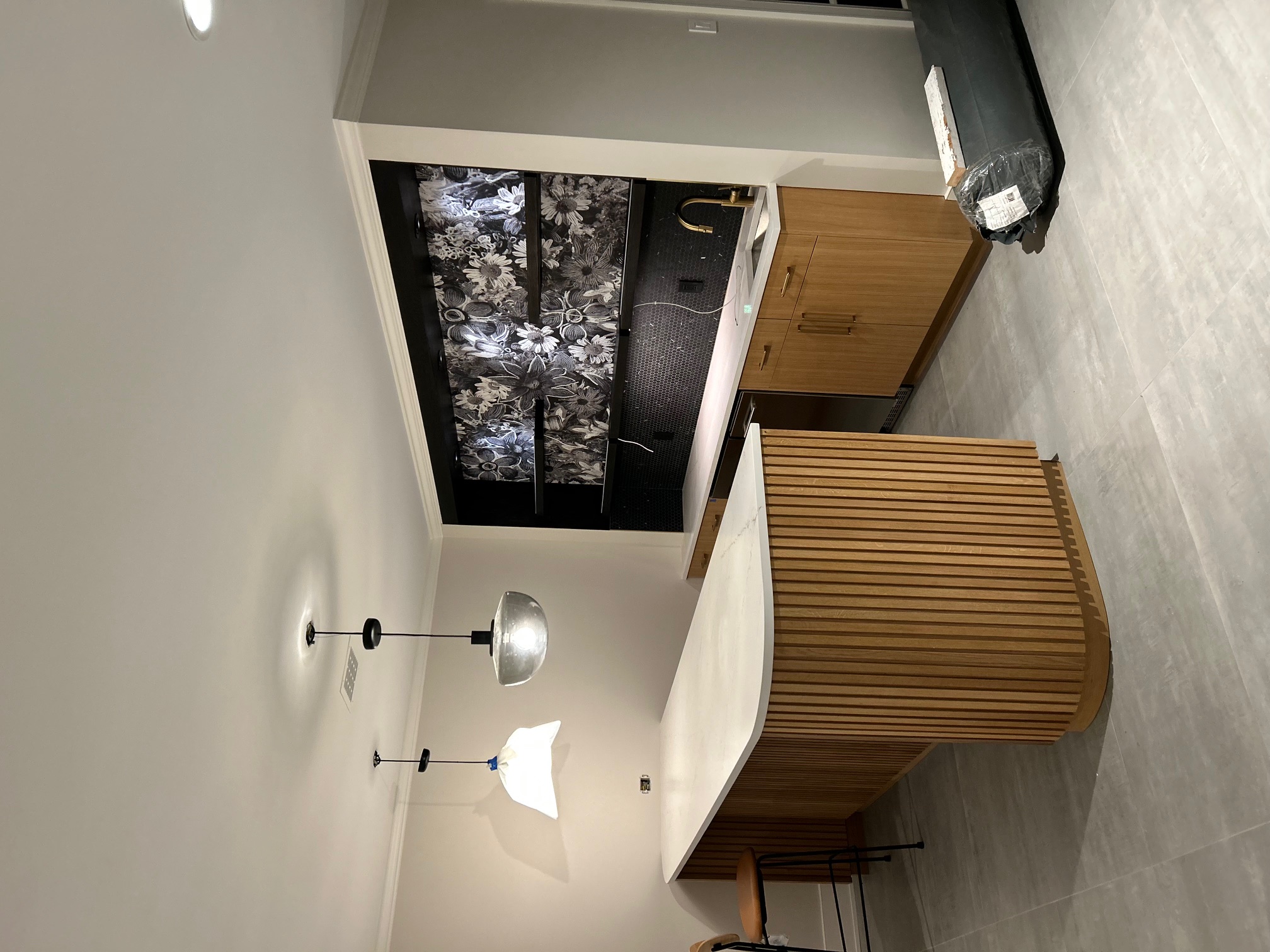 Basement bar with curved reeded white oak island and coordinating cabinetry