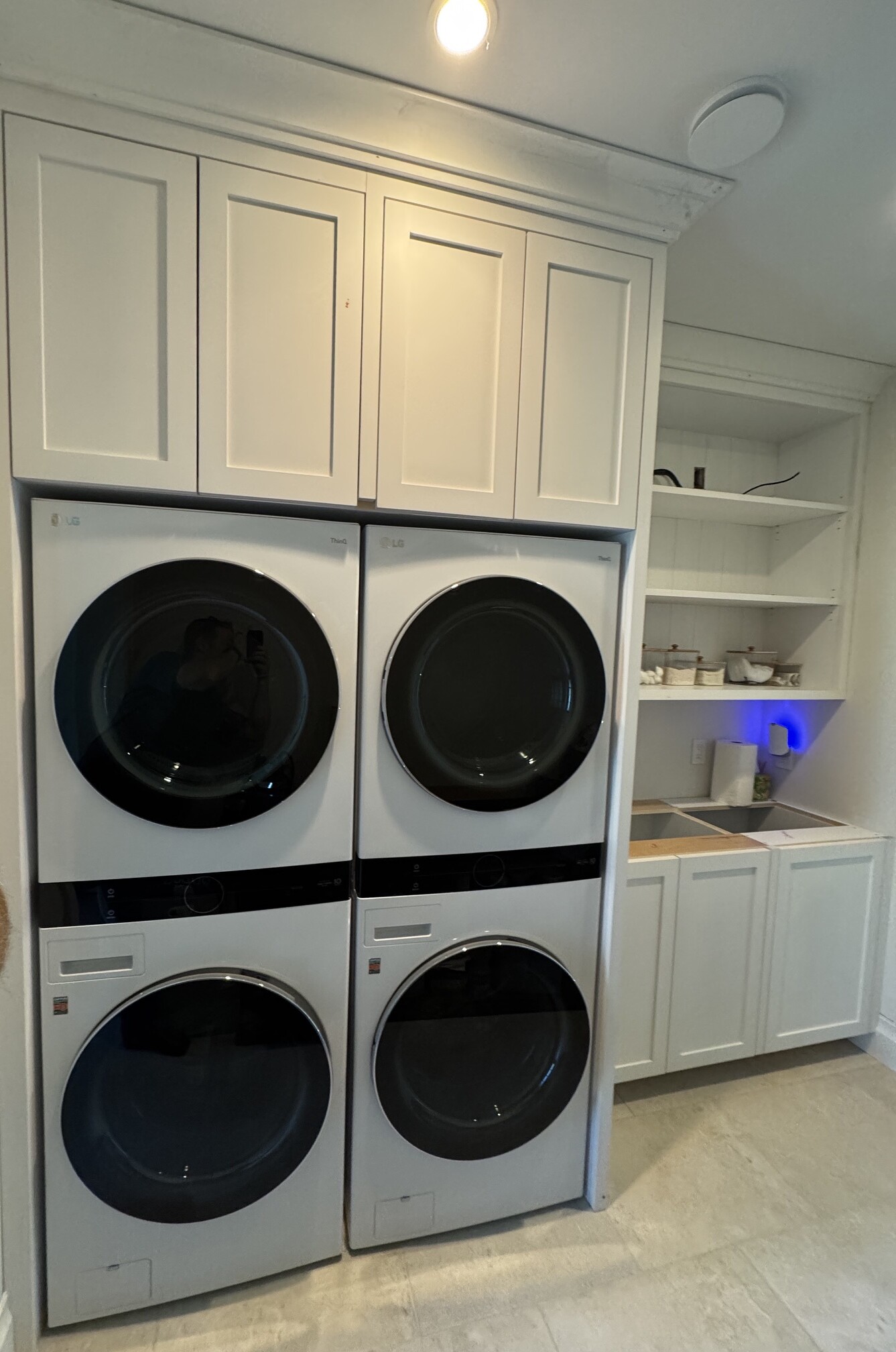 Painted custom laundry cabinetry built around stacked washers and dryers