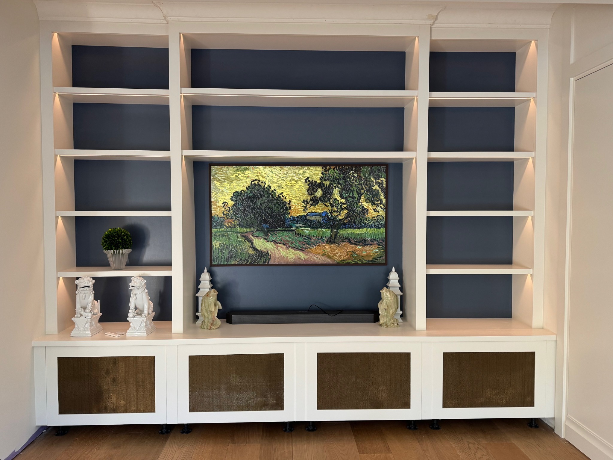 Custom illuminated media wall with painted millwork and inset blue panels in Quogue