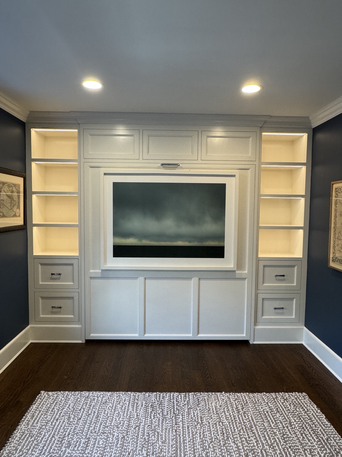 Completed Watermill Murphy bed closed with framed artwork, illuminated shelves and installed drawer hardware